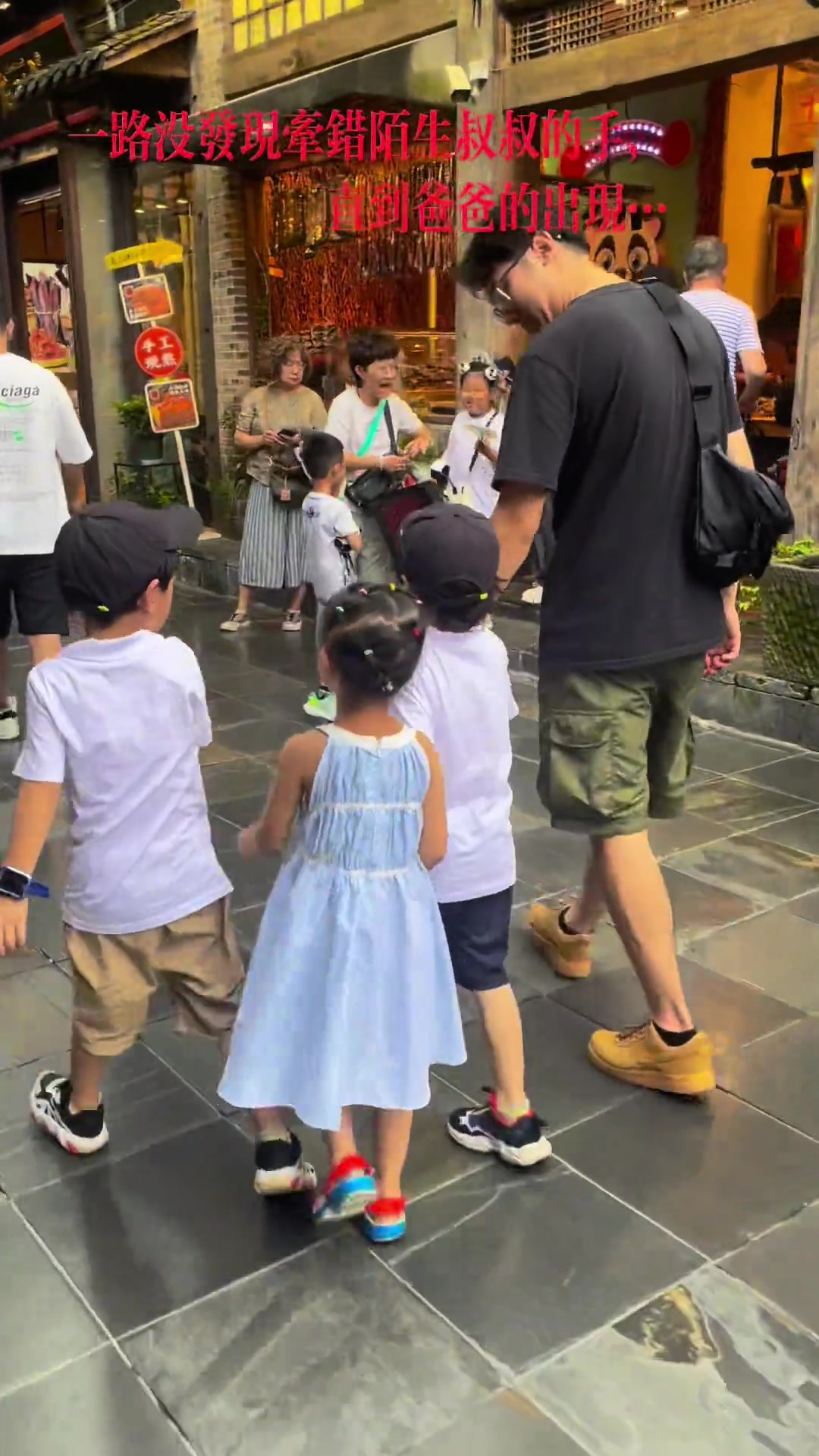 当孩子在街上牵了位和爸爸穿一样颜色衣服