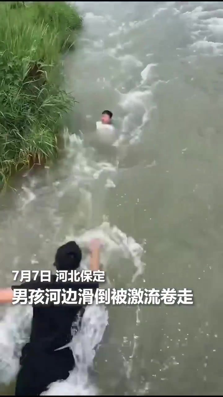 男孩河边滑倒被湍急的水流卷走，大哥纵身一跃跳入水中救起了孩子