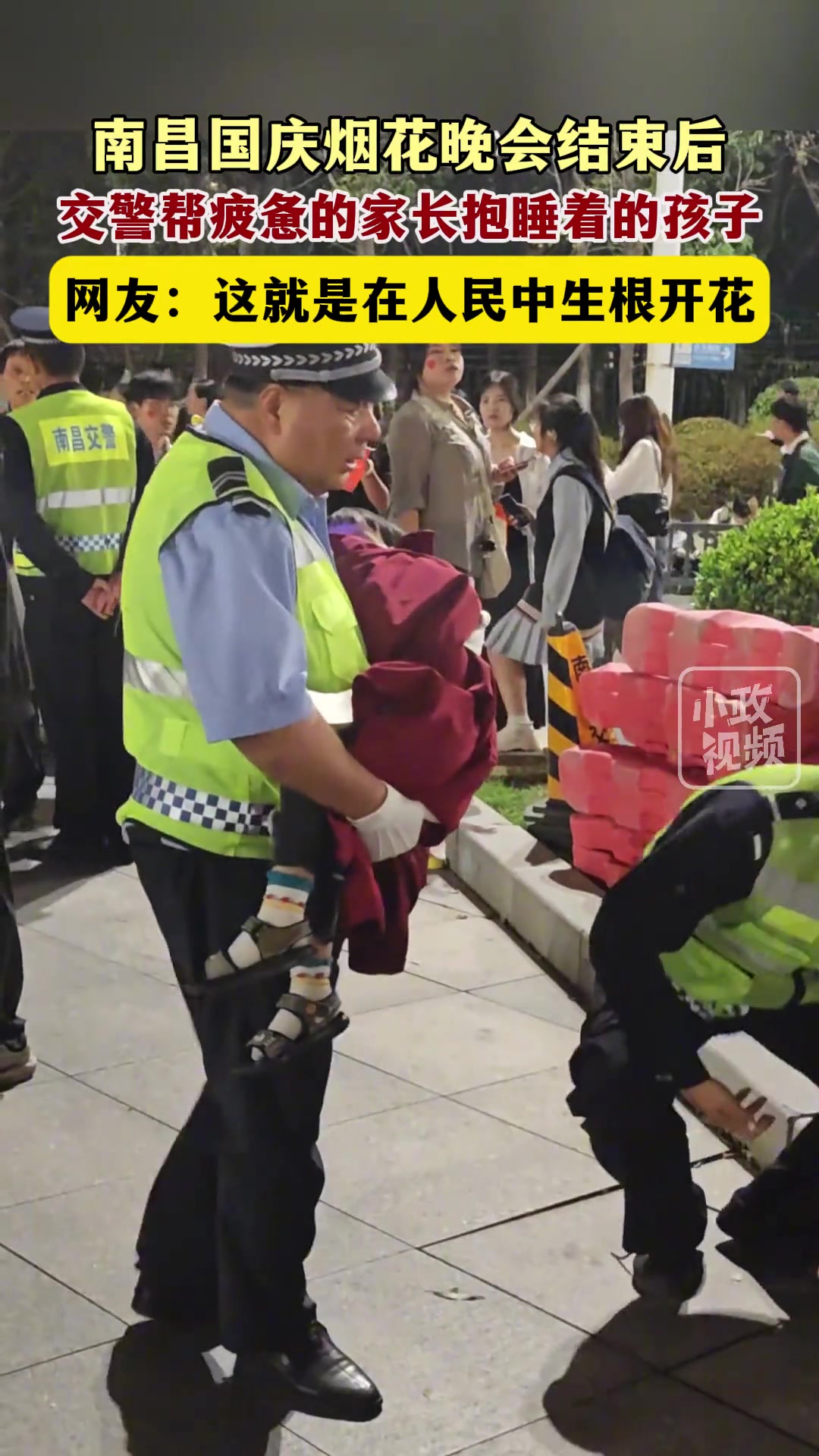 南昌国庆烟花晚会结束后，交警帮疲惫的家长抱睡着的孩子