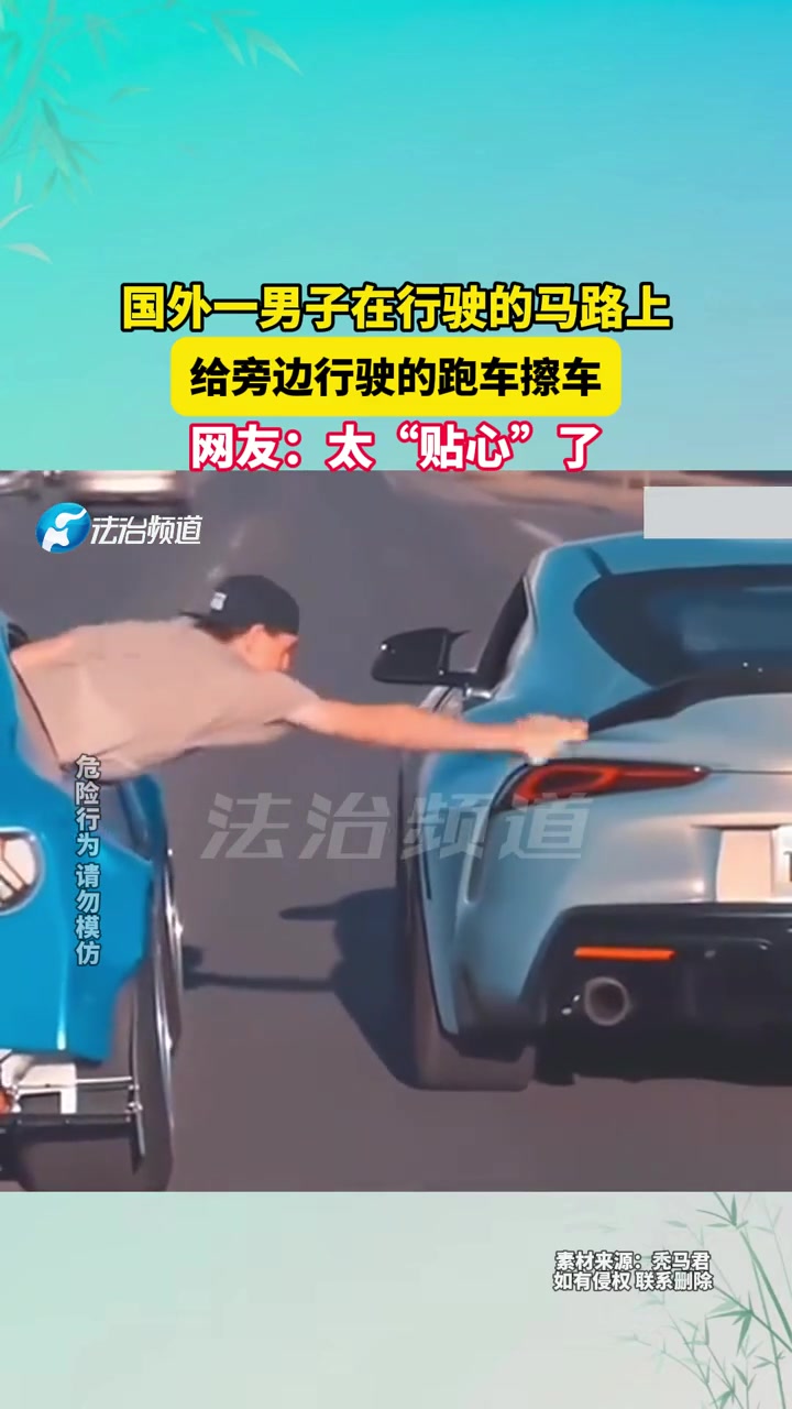 男子在行驶的马路上，给旁边行驶的跑车擦车