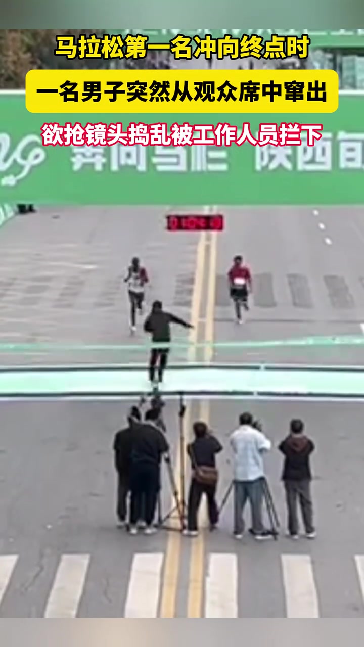 马拉松第一名冲向终点时，一名男子突然窜出，欲捣乱！