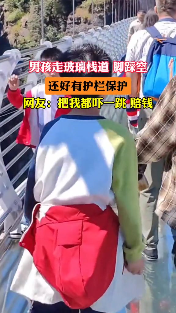 男孩走玻璃栈道脚踩空，还好有护栏！