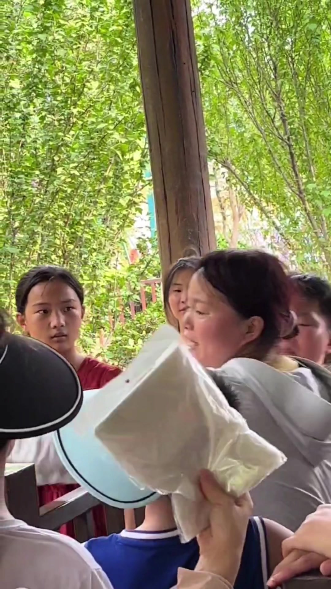 女子带孩子插队，被其他游客指责，孩子多次捂住她的嘴巴防止吵架