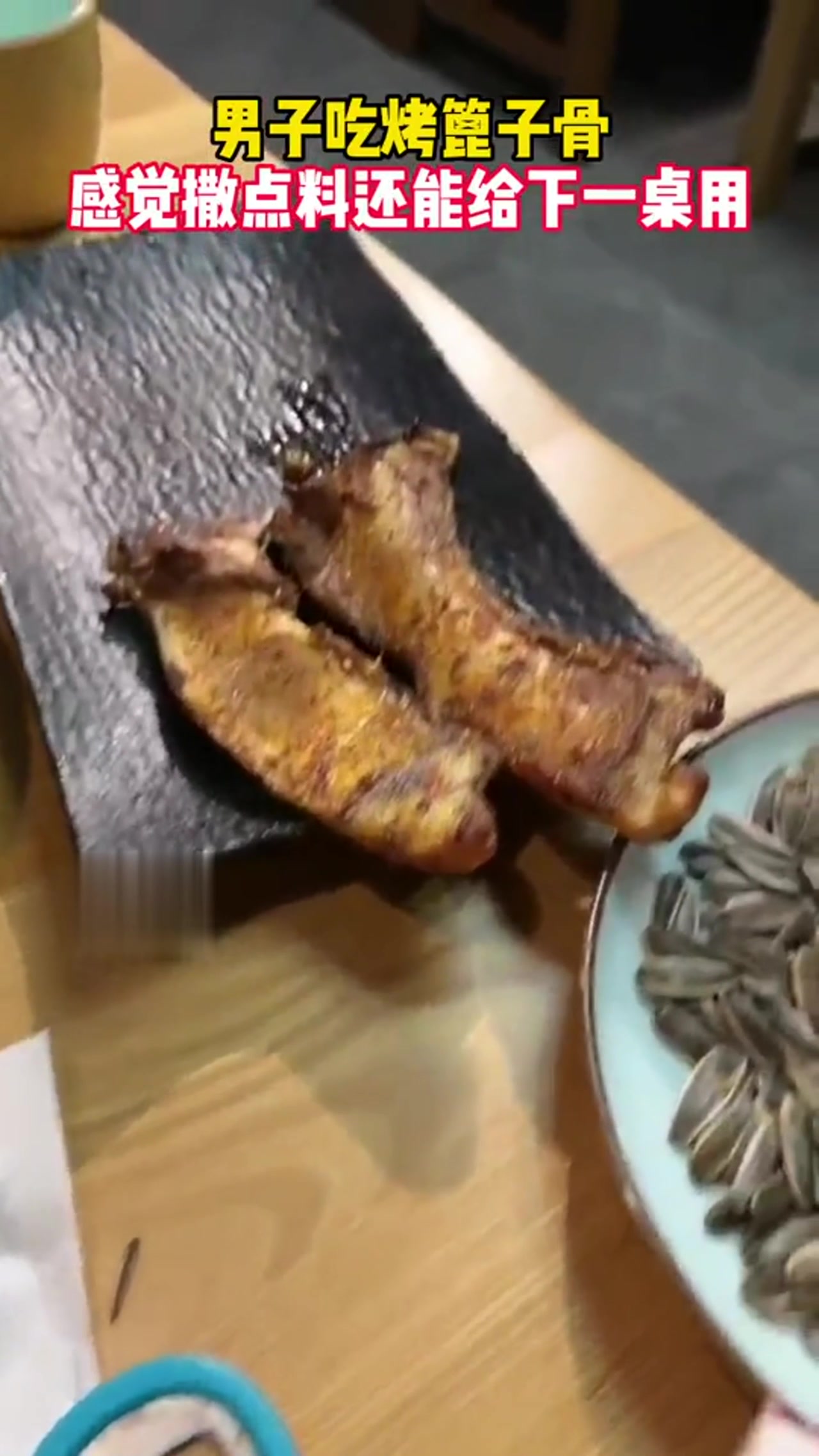 男子吃烤篦子骨，感觉撒点料还能给下一桌用！