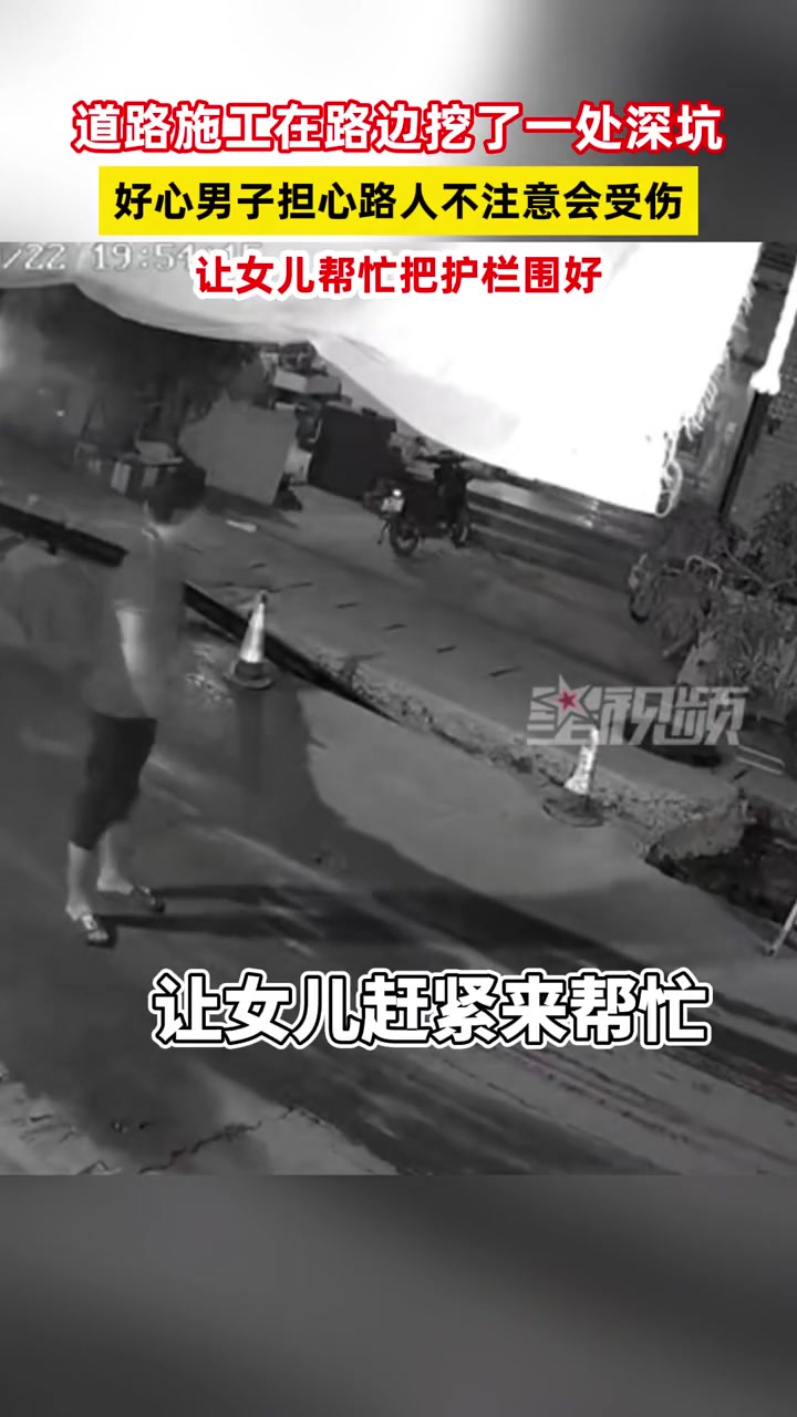 道路施工路面挖了一处深坑,好心男子和女儿帮忙把护栏围好