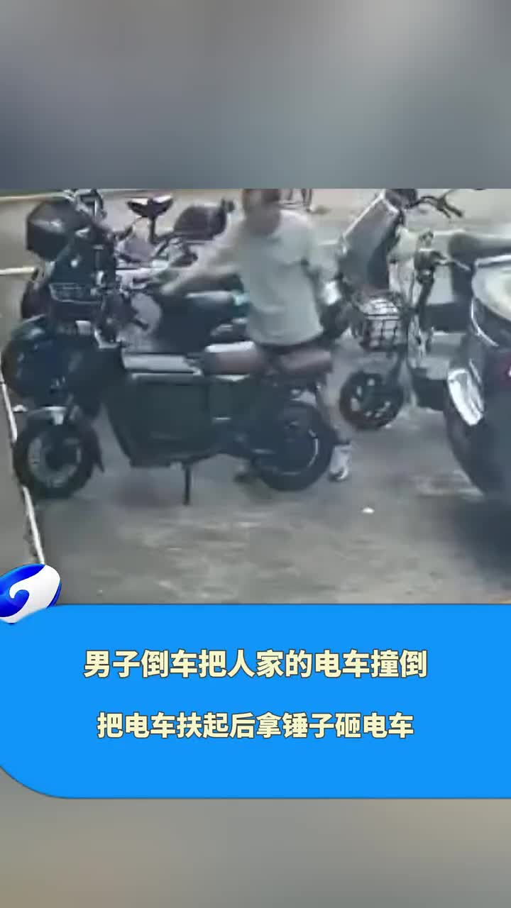 男子倒车把电车撞倒，不情不愿把电车扶起后拿锤子砸电车！