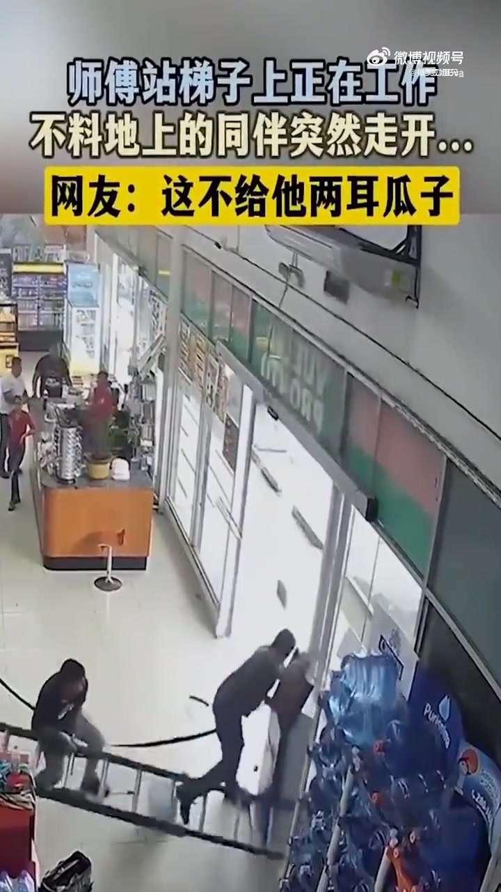 师傅站梯子上正在工作，不料地上的同伴突然走开！
