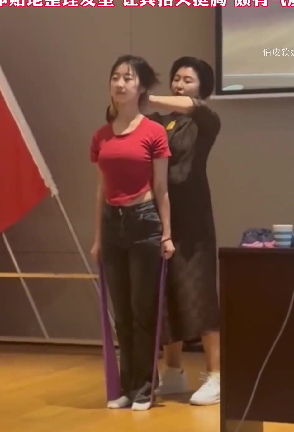 女生记录下大学迎春晚会上，老师在台上帮忙给自己矫正形体仪态