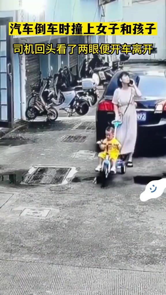汽车倒车时撞上了抱着小孩的女子，司机回头看了两眼便开车离开