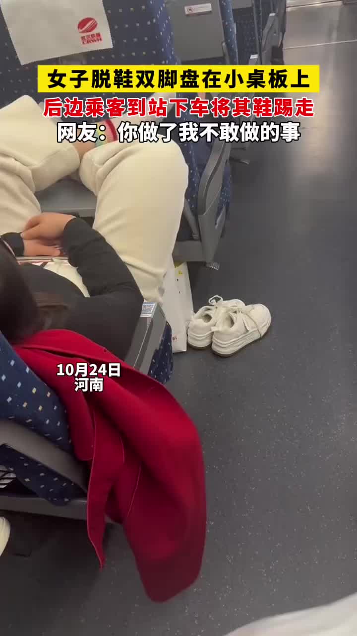高铁上女子脱鞋双脚盘在小桌板上，后边乘客下车时将其踢走