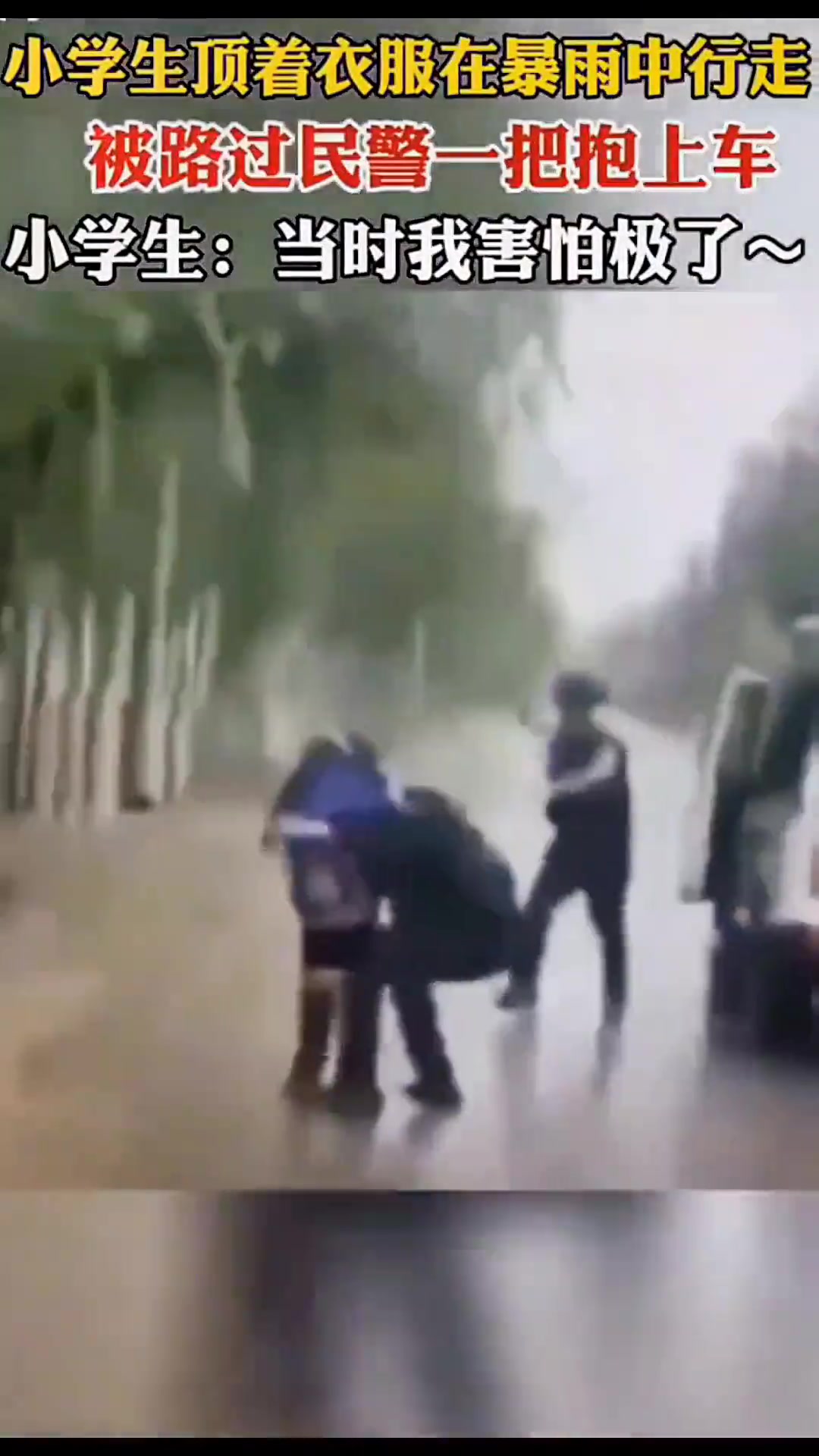 小学生顶着衣服在暴雨中行走，被路过民警一把抱上车