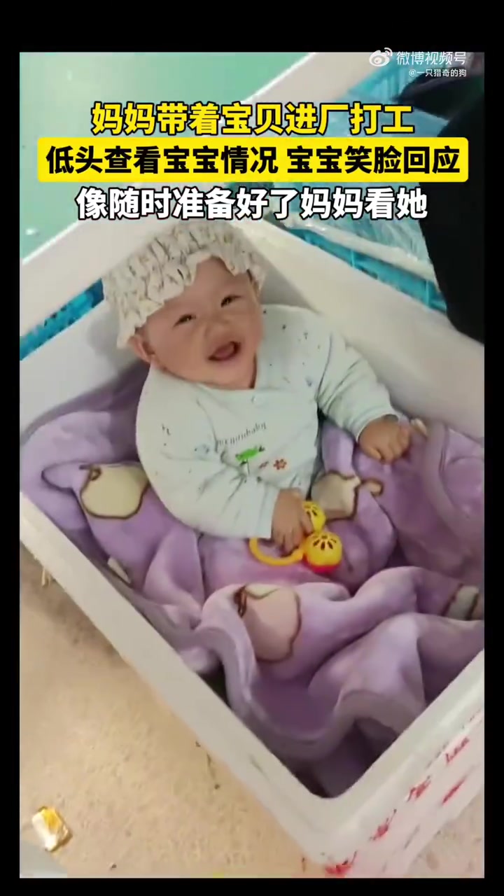 妈妈带着宝宝进厂打工，妈妈低头查看宝宝情况，宝宝也笑脸回应！