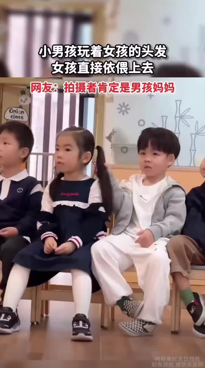 小男孩玩着女孩的头发，女孩直接靠了上去