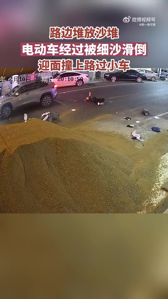 路边堆放沙堆，电动车路过被滑倒撞上路过小车！