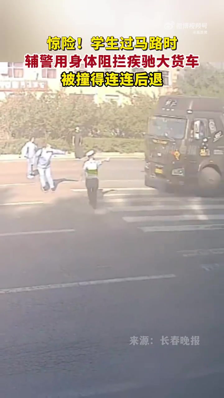 学生过马路时辅警用身体阻拦疾驰的大货车，被撞得连连后退