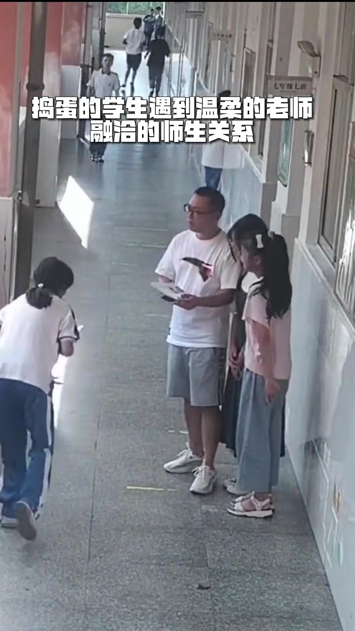 老师在给学生讲题，一个女生过来恶作剧，把他的帽子给掀翻了！