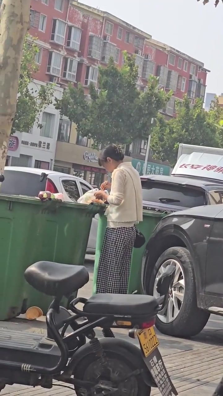 这是受什么刺激了，看着穿的也干干净净的，在垃圾桶找剩菜饭吃