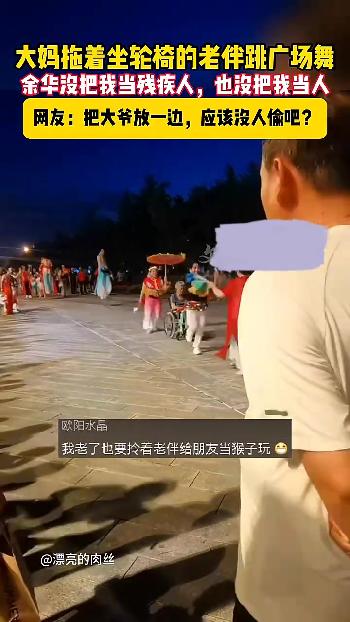 大妈拖着坐轮椅的老伴一起跳广场舞