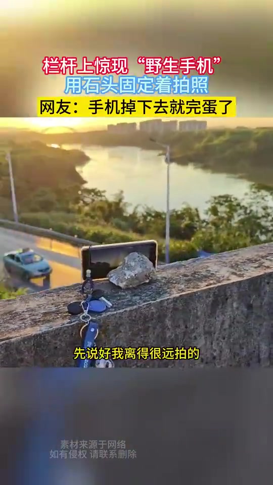 栏杆上惊现“野生手机”，用石头固定着拍照