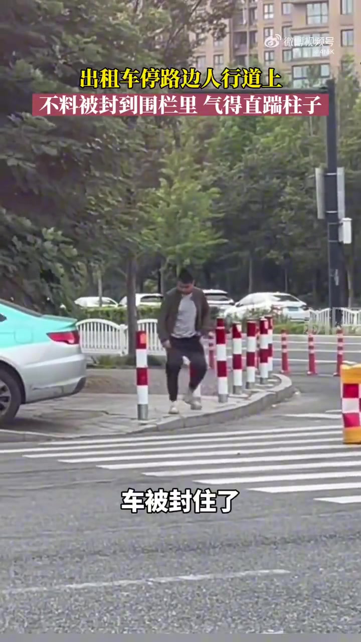 出租车停路边人行道上，不料被封到围栏里，气得直踹柱子.
