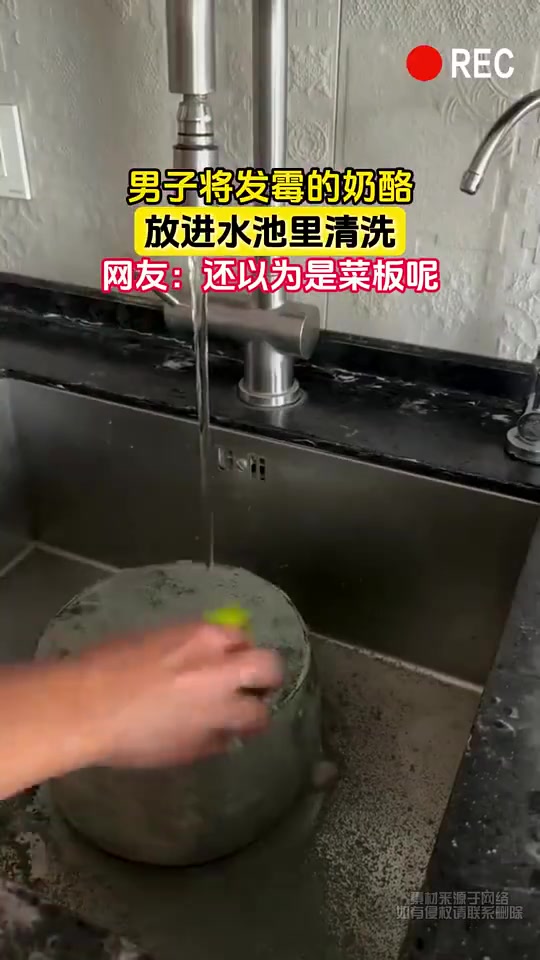 男子将发霉的奶酪，放进水池里清洗