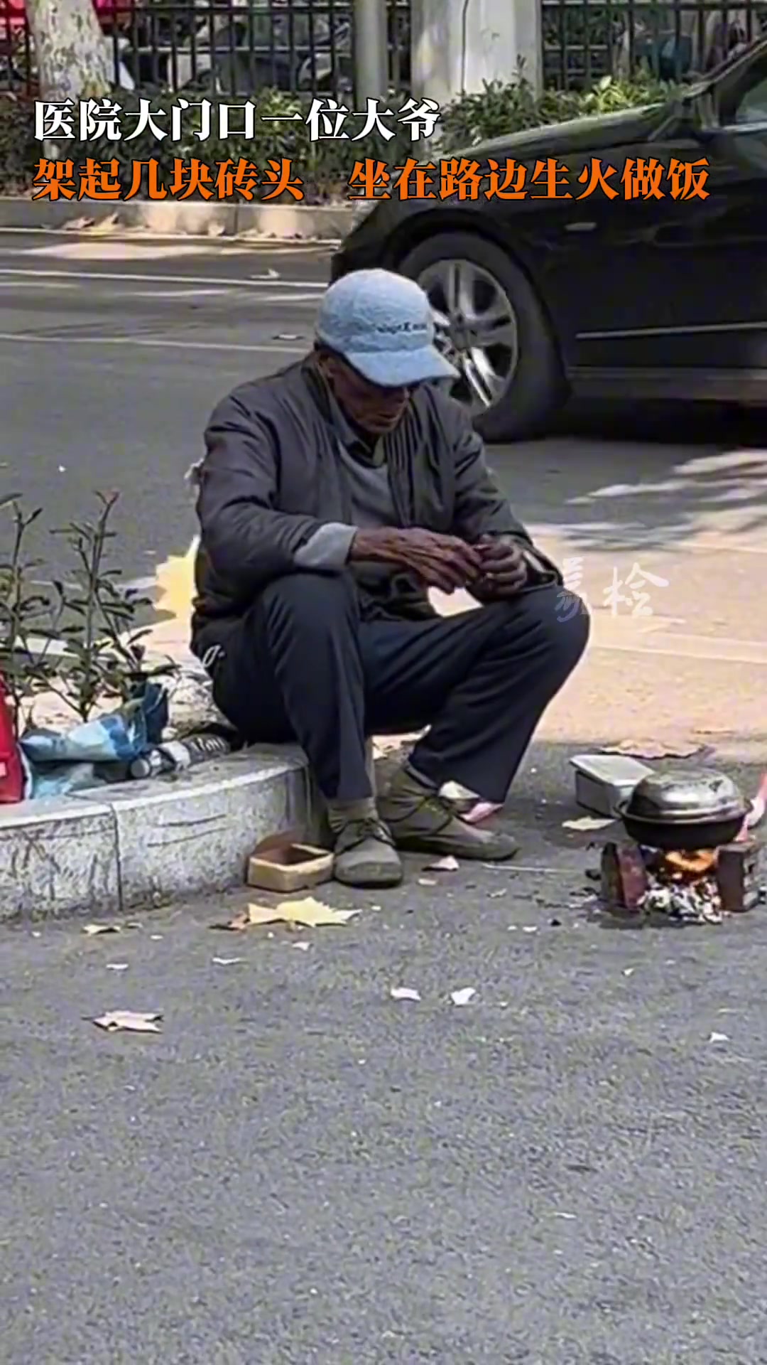 医院门口一大爷架起几块砖头坐在路边生火做饭