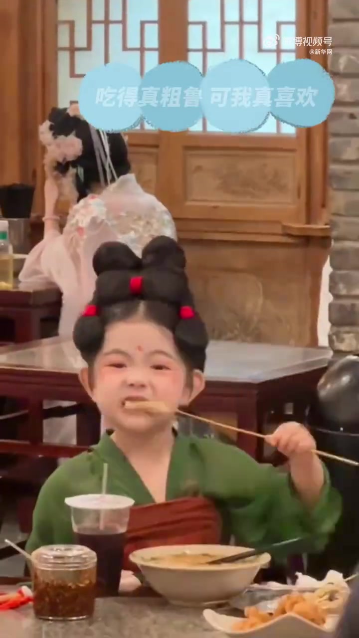 一汉服装扮的小女孩在馆子里，吃面撸串，十分可爱