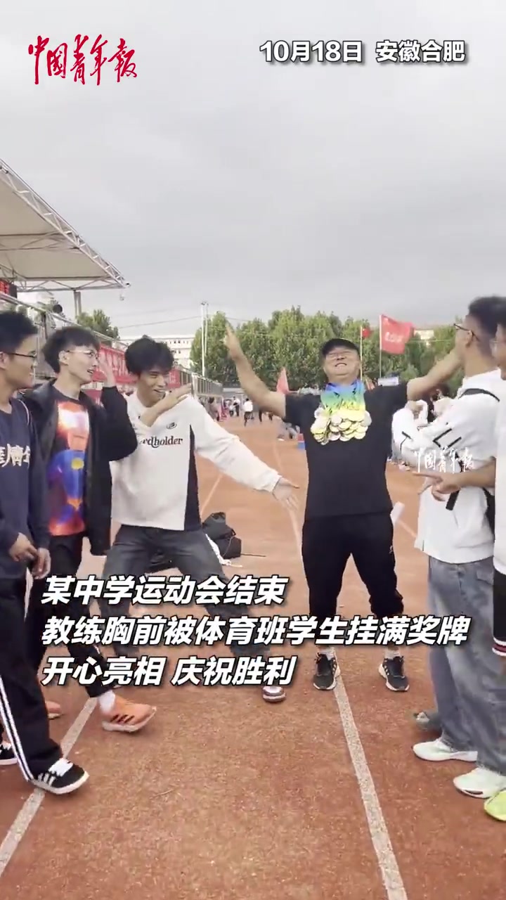 教练胸前被体育班学生挂满奖牌，开心亮相，庆祝胜利