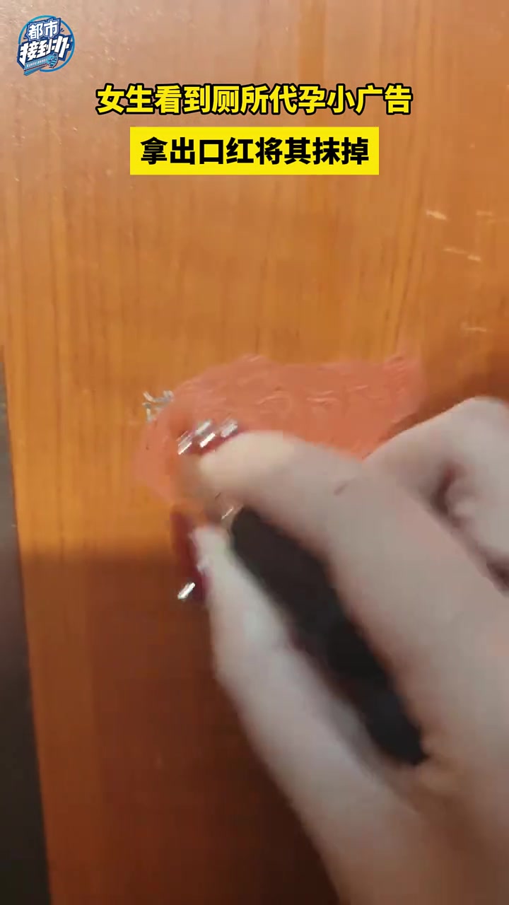 女生看到厕所代孕小广告，拿出口红将其抹掉