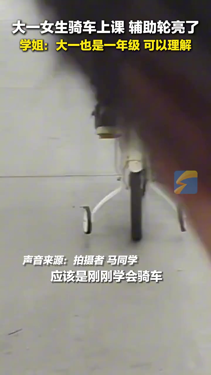 大一女生骑自行车上课，后面的两个辅助轮亮了！
