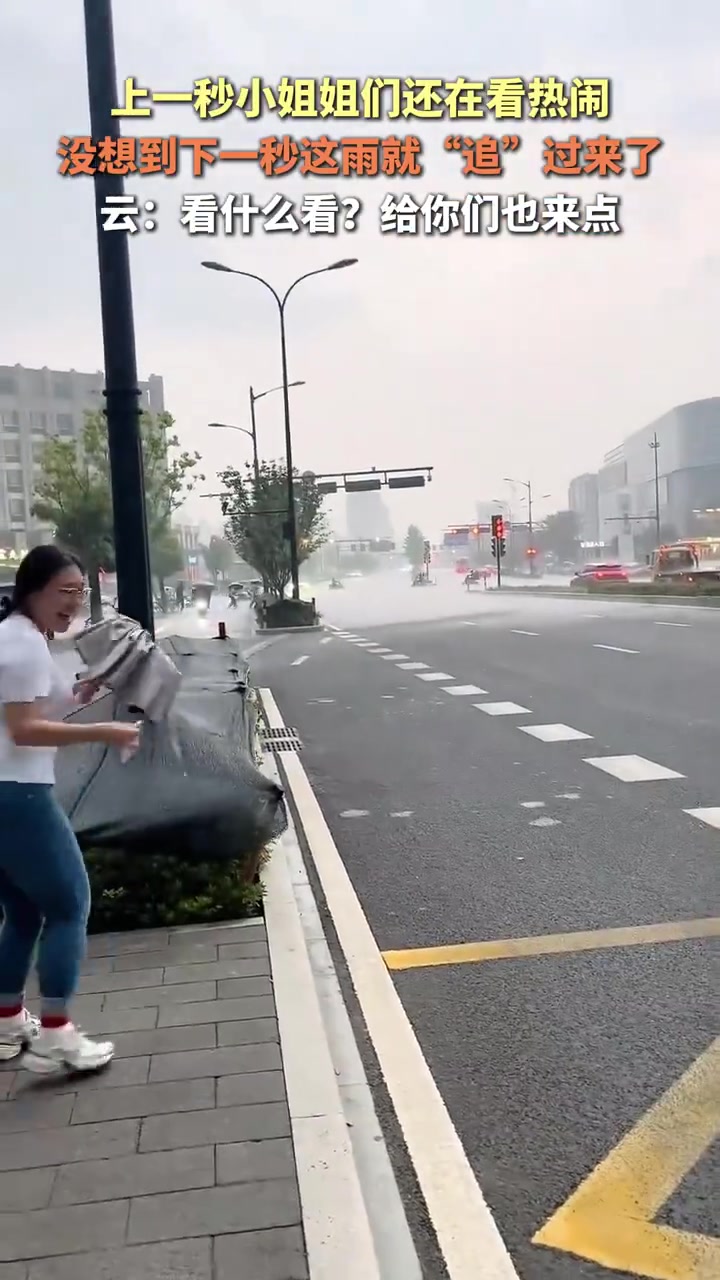 上一秒小姐姐们还在看热闹，没想到下一秒这雨就“追”过来了