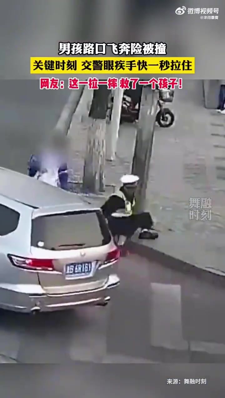 男孩路口飞奔险被撞，交警一秒拉住，网友：一拉一摔救了孩子