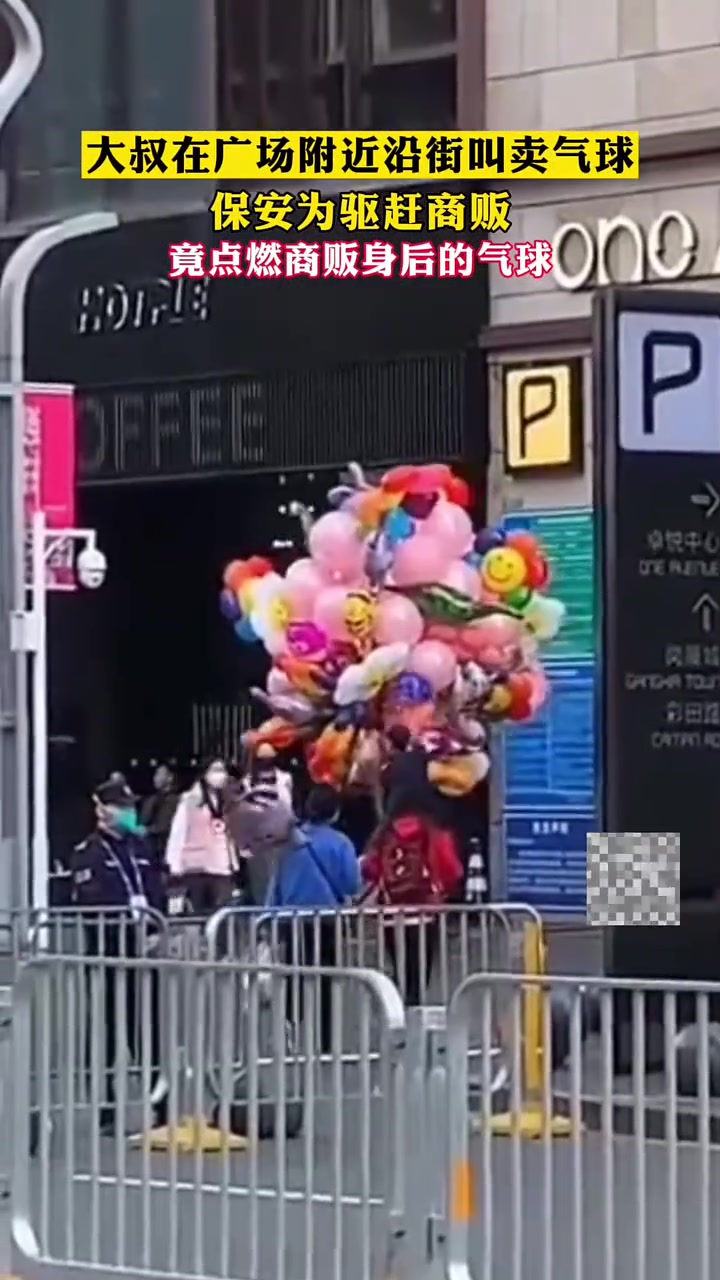 大叔在广场附近沿街叫卖气球保安为驱赶商贩竟点燃商贩身后的气球