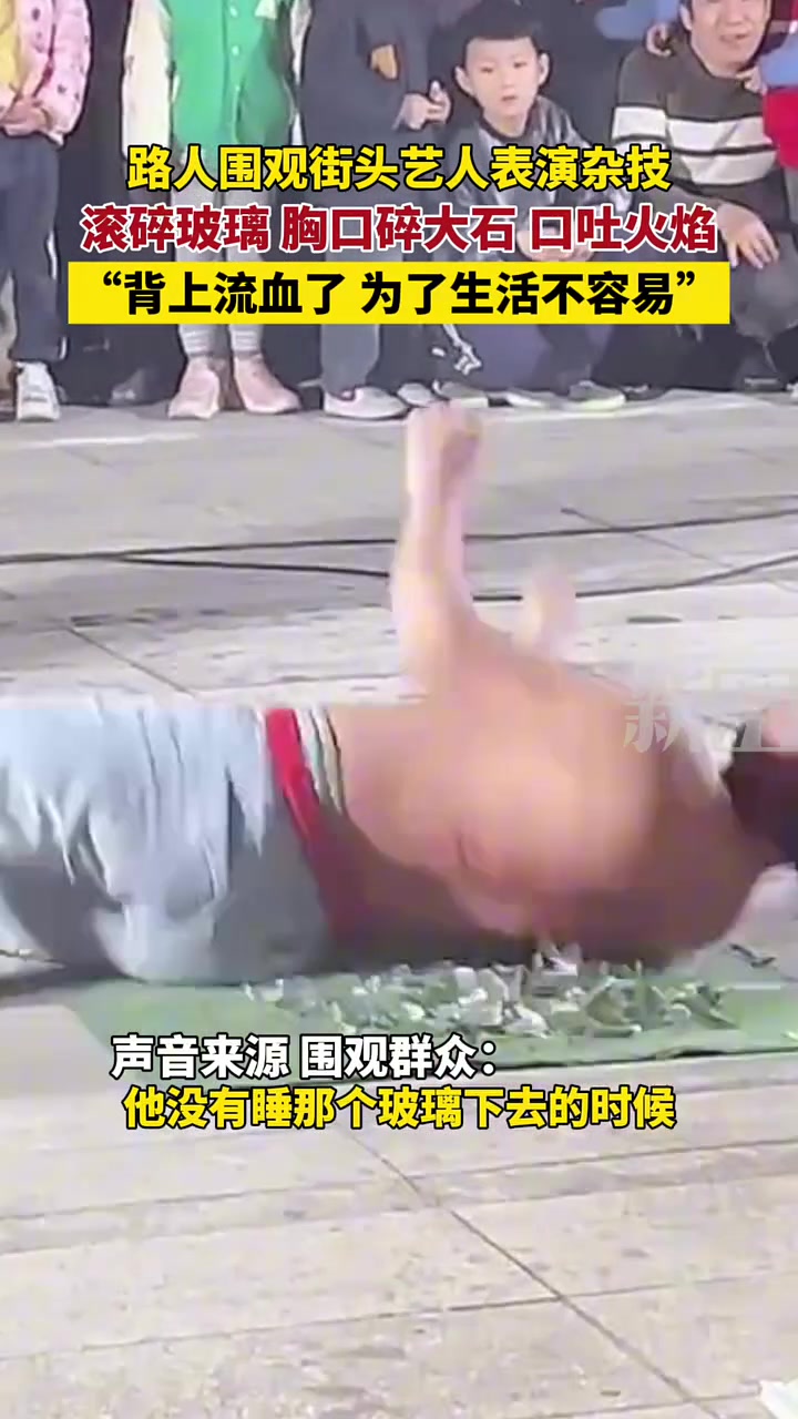 路人围观街头艺人表演杂技，滚碎玻璃，胸口碎大石，口吐火焰