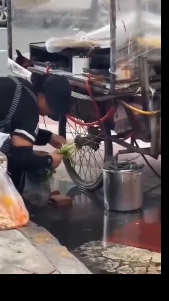 万万不敢相信摊主借用路边积水简单洗个菜