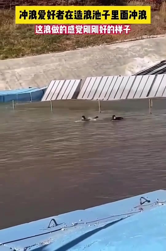 冲浪爱好者在造浪池子里面冲浪