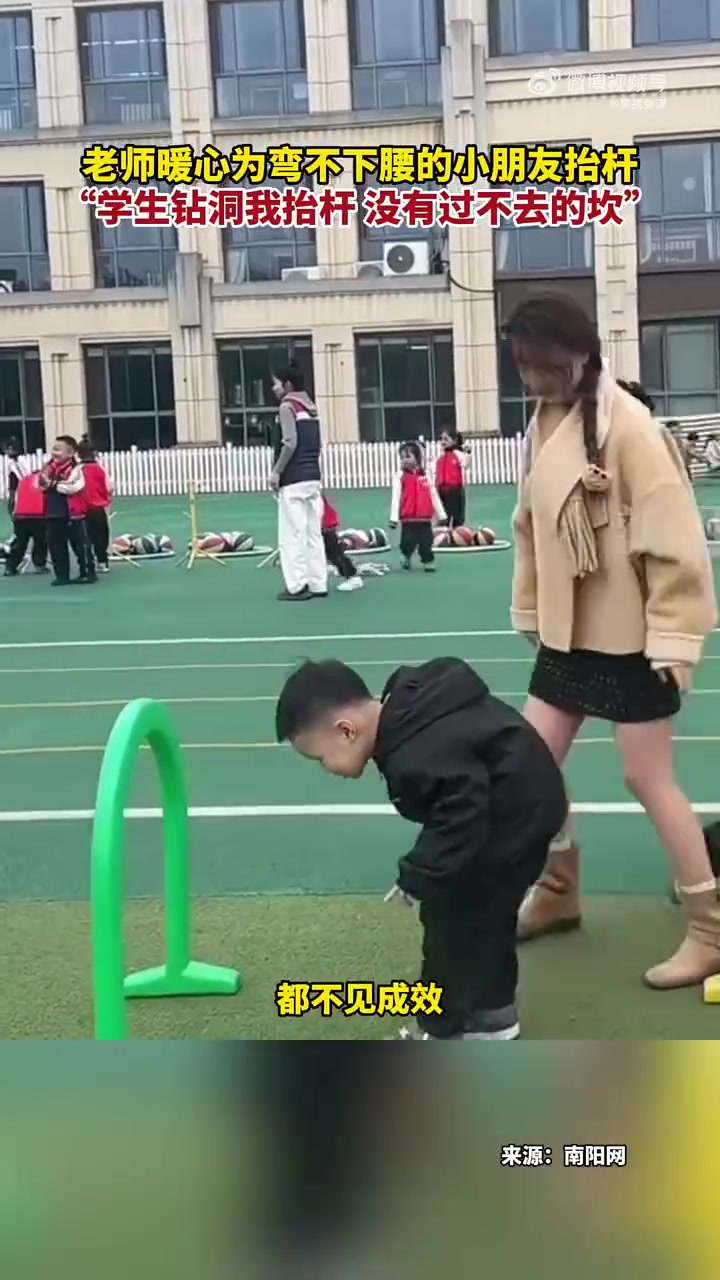 老师暖心为弯不下腰的小朋友抬杆