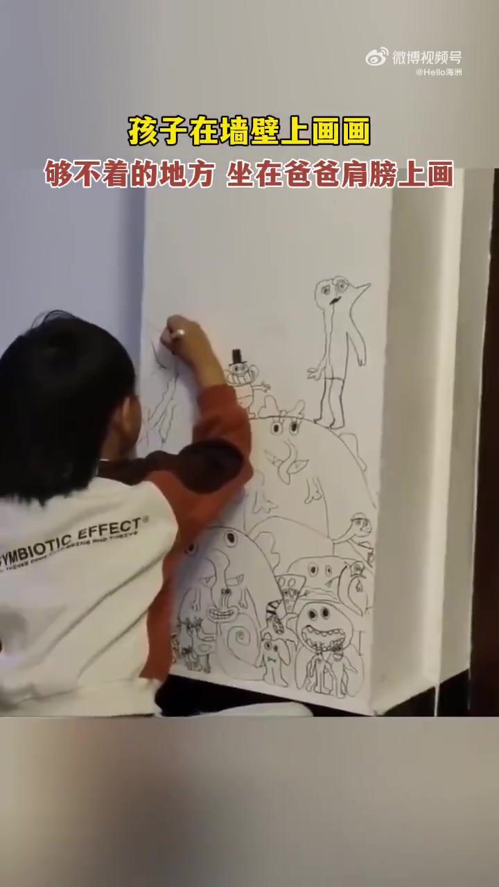 孩子在墙壁上画画，够不着的地方坐在爸爸肩膀上画
