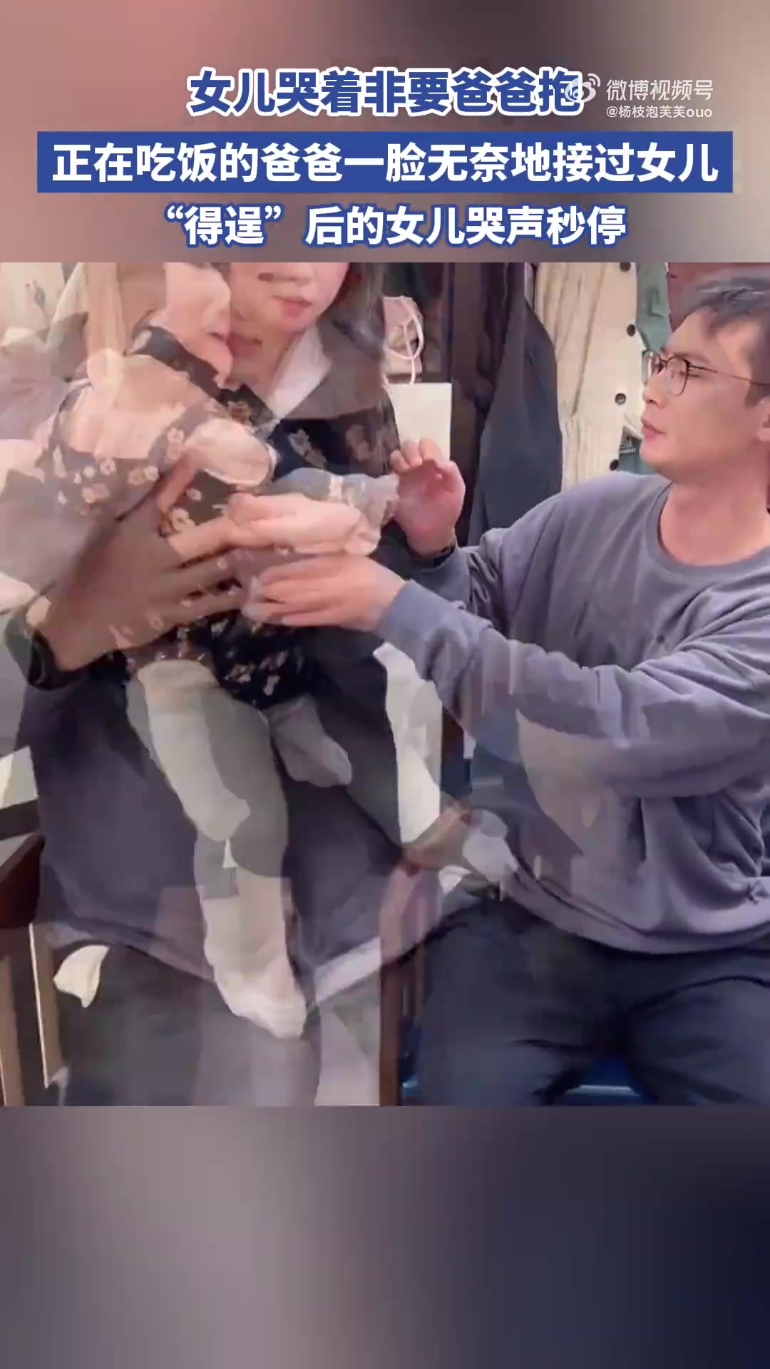 女儿哭着非要爸爸抱，正在吃饭的爸爸，一脸无奈地接过女儿