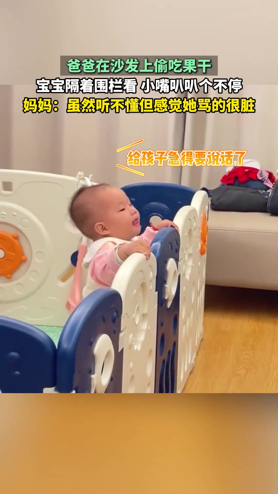 爸爸在沙发上偷吃果干，宝宝隔着围栏看，小嘴叭叭个不停