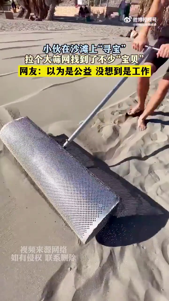小伙在沙滩上“寻宝”，拉个大筛网找到了不少“宝贝”