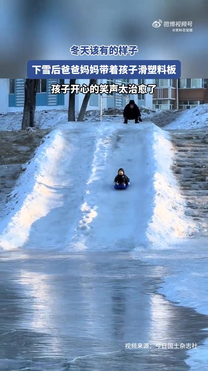 下雪天爸爸妈妈带孩子滑塑料板，笑声很治愈