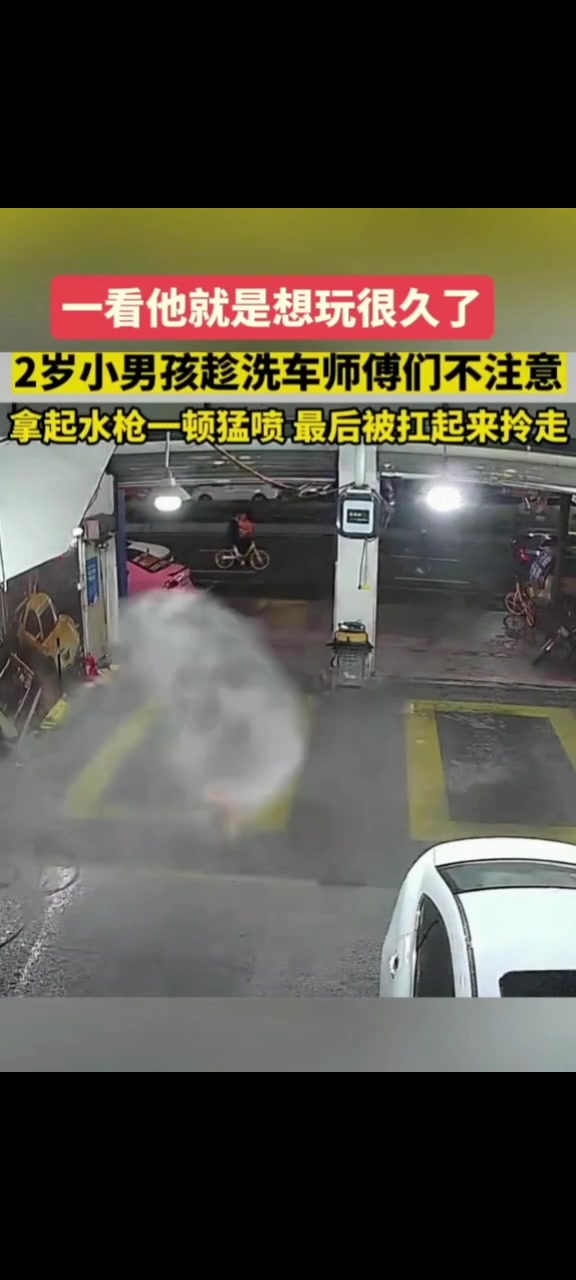 小男孩趁洗车师傅不注意拿起水枪一顿猛喷