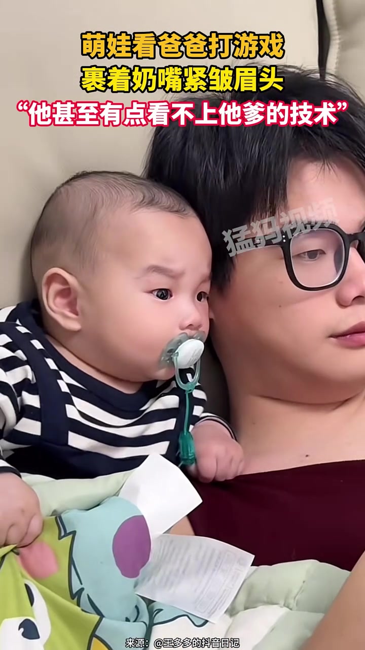 萌娃看爸爸打游戏，裹着奶嘴紧皱眉头，他甚至看不上他爹的技术