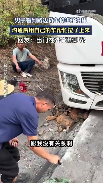 男子看到路边货车掉进了沟里沟通后用自己的车帮忙拉了上来