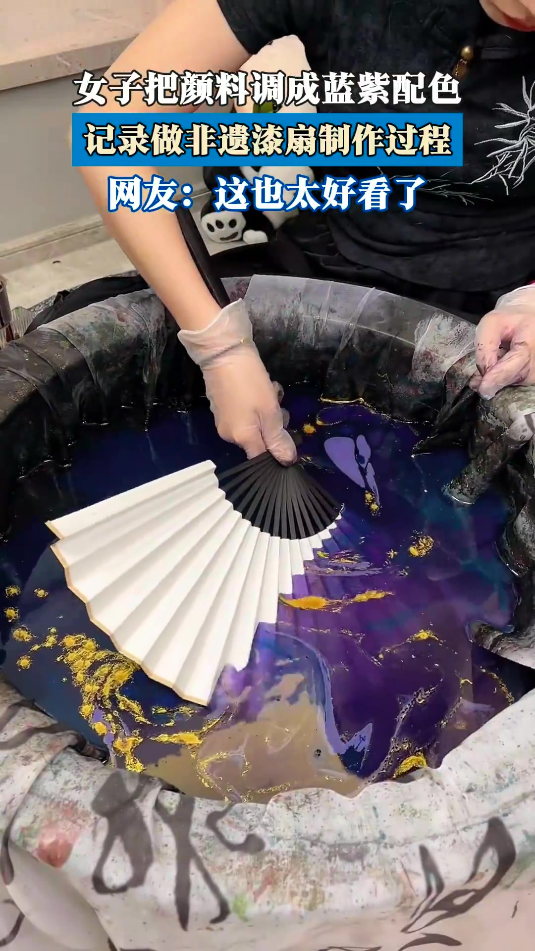 女子将颜料调成蓝紫配色，记录非遗漆扇制作过程