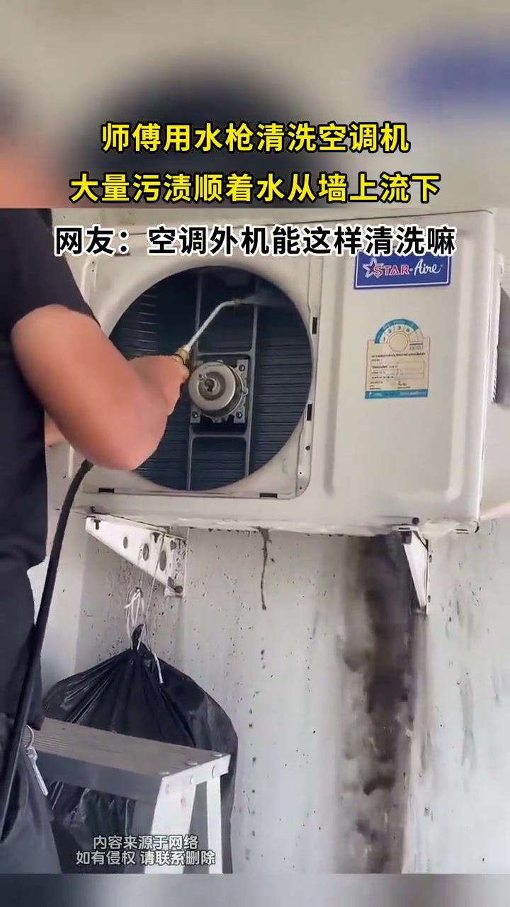 师傅用水枪清洗空调机大量污渍顺着水从墙上流下