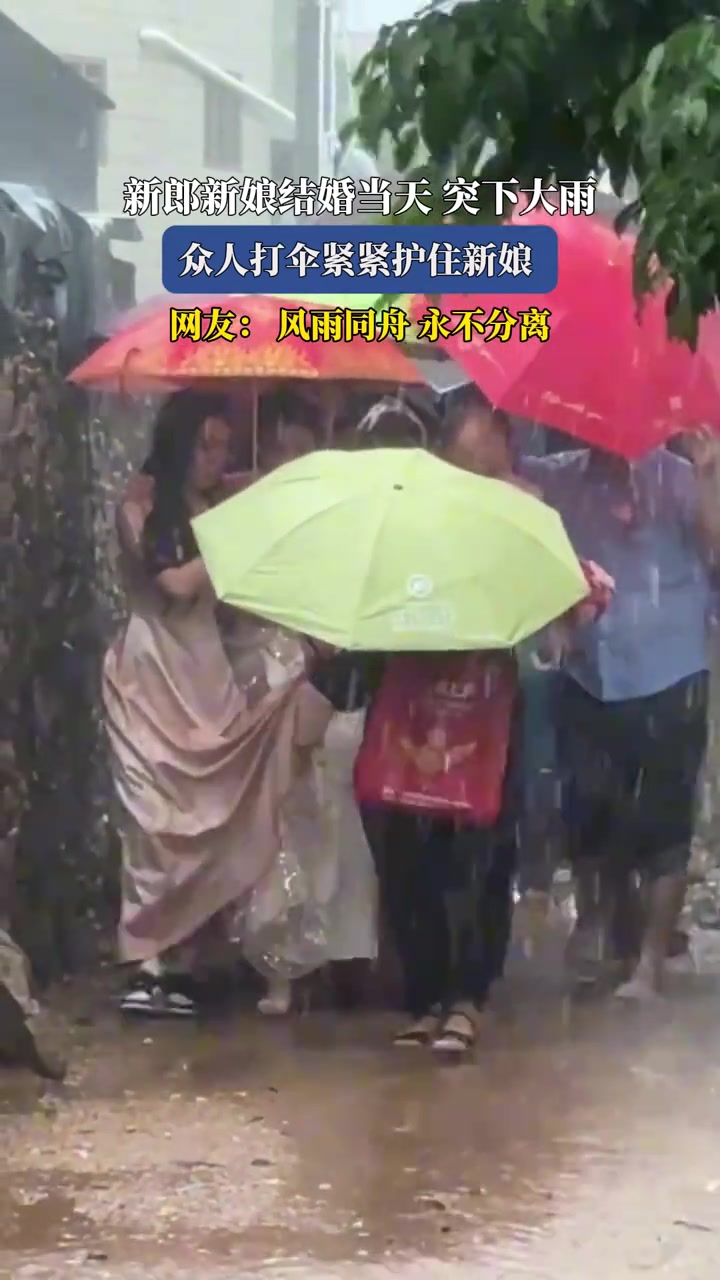 新郎新娘结婚当天突下大雨众人打伞紧紧护住新娘
