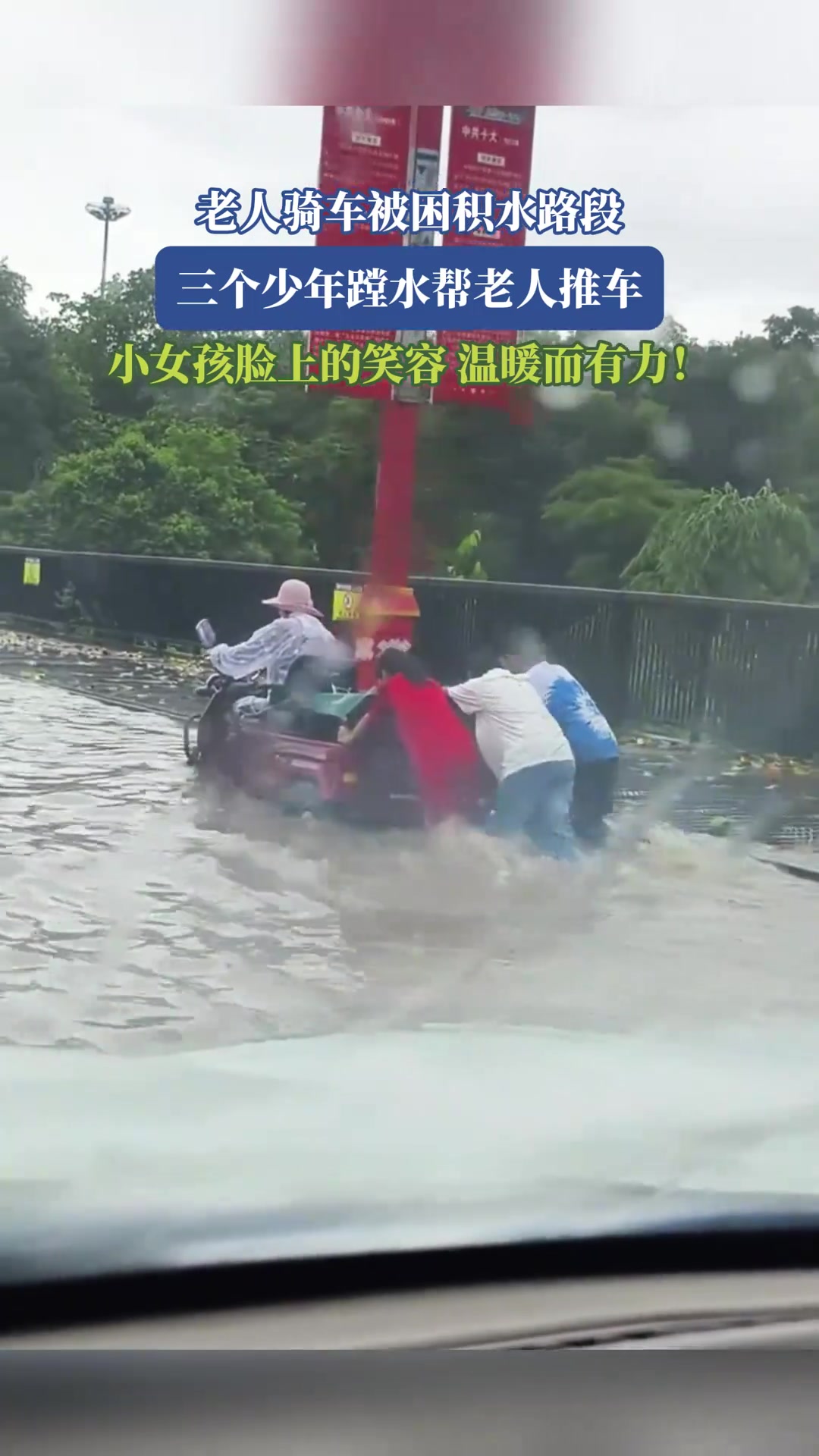 老人骑车被困积水路段，三个少年蹚水帮老人推车