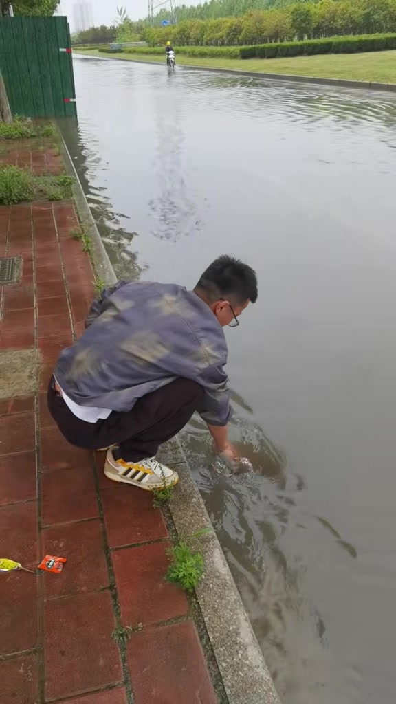 路边下水口被杂物堵住了，好心人直接徒手清理